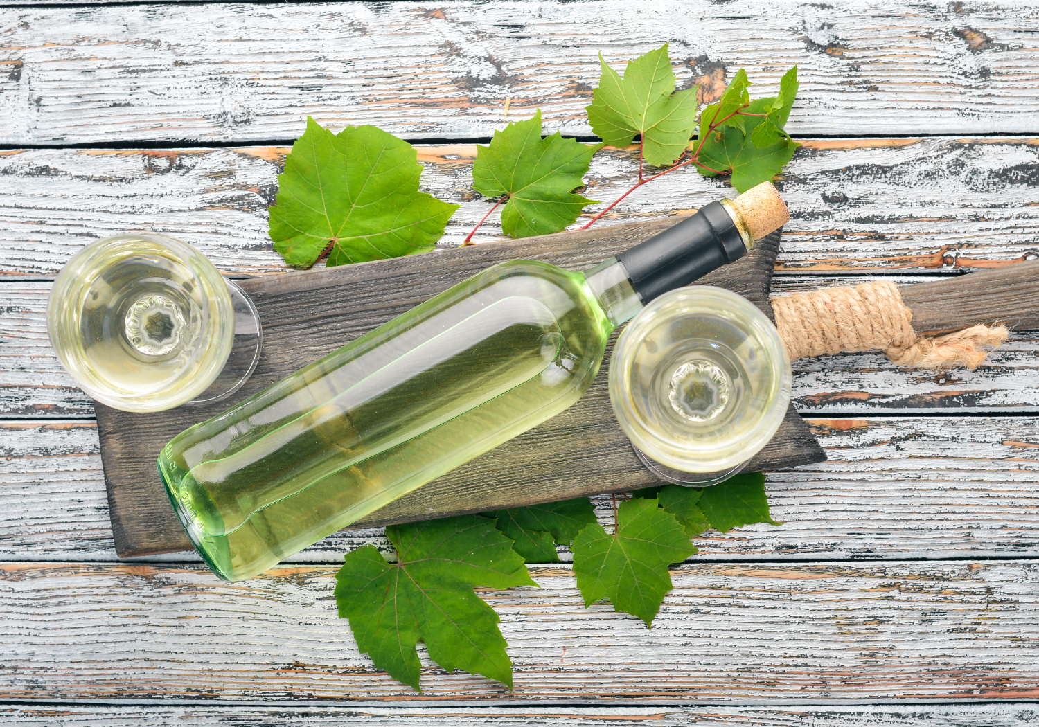 white-wine-bottle-with-glass-grapes-white-wooden-background-free-space-text-top-view